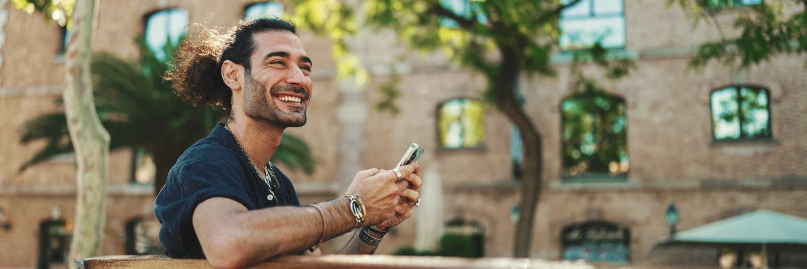 Business owner smiling at a booking confirmation on his phone